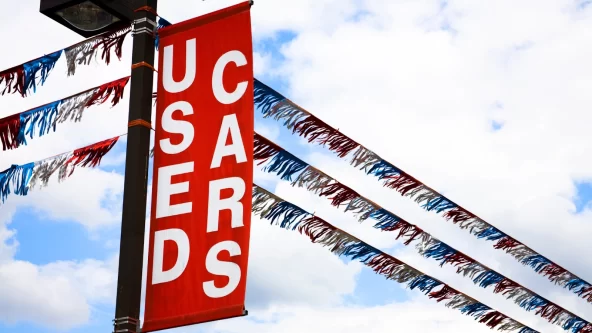 red and white used cars banner above a car yard